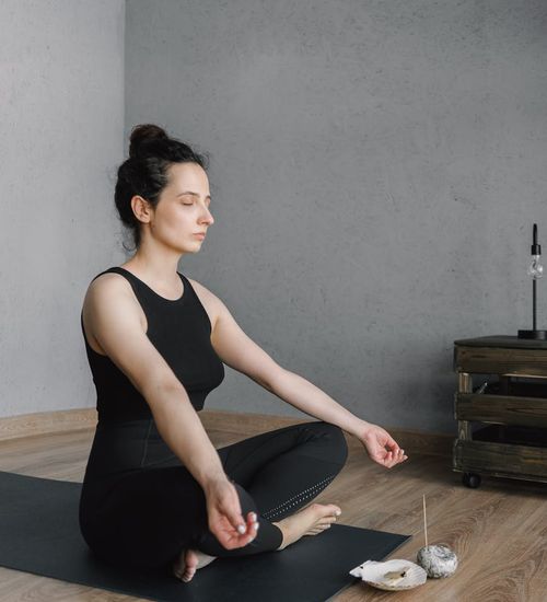 Woman feeling energetic and balanced in a modern, dark room.